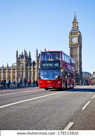 LONDON - DEC 29: Iconic London bus crossing Westminster Bridge in the United Kingdom December 29, 2013 in London, England