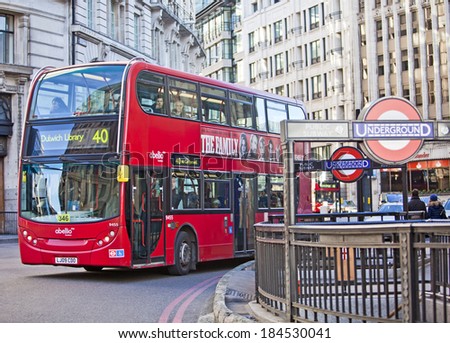 London, United Kingdom - 29th DEC 2013: Iconic red London bus drives through city street past an Underground station