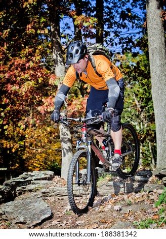Mountain biker riding through countryside during autumn