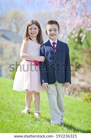 A young boy and girl standing outside portrait