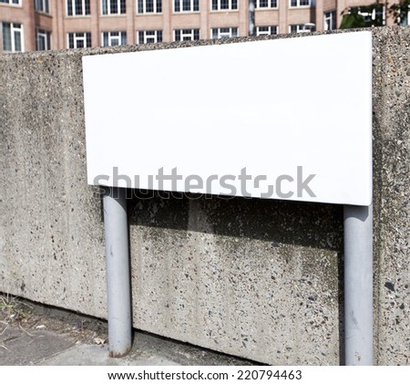 Blank street sign against a concrete wall