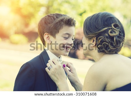 Mother fixing bow tie on son candid moment