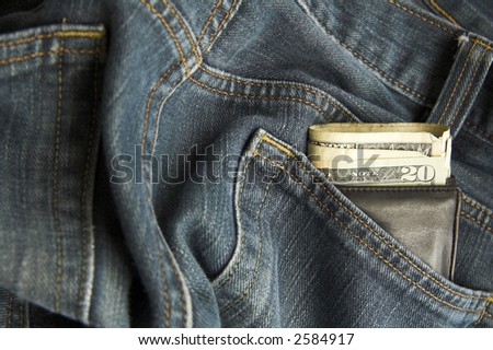 Dollars showing in wallet in jeans back pocket