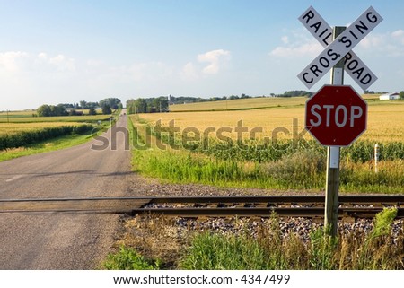 Railroad crossing and stop sign in farmland