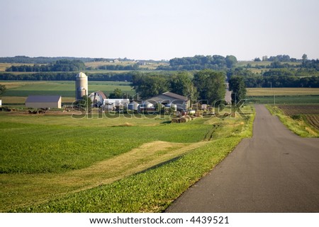 Farm shown along a wide road at dusk