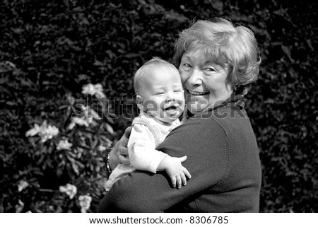 Grandmother hugging happy grandson in sunny garden