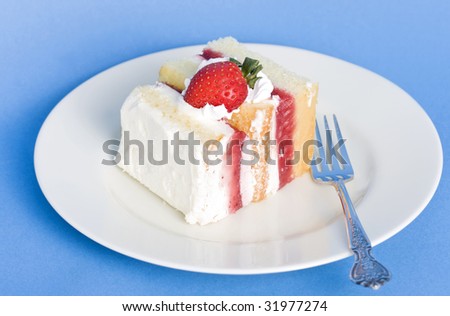 Strawberry cream cake on a textured blue background and small shadow