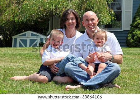 Beautiful family sitting on grass portrait