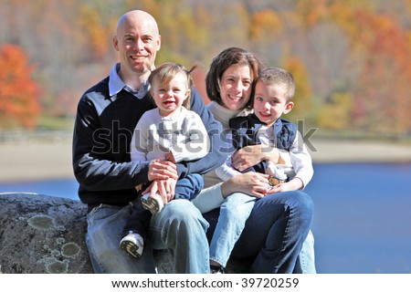 Beautiful family portrait with fall trees background