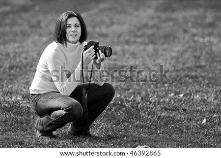 Pretty woman crouching with camera