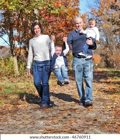 Happy family walking on path during autumn