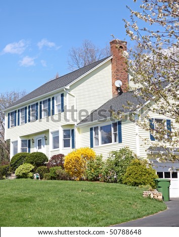Yellow New England Style colonial house on a spring day