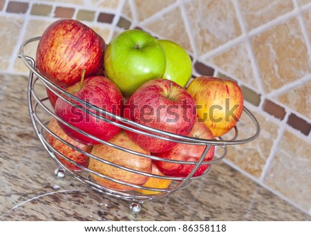 Stainless steel basket of red and green apples