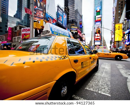 NEW YORK DECEMBER 17 Yellow cab speeds through Times Square the busy tourist intersection of neon art and commerce and is an iconic street of New York City on Dec 17th 2011 in New York NY USA NEW YORK DECEMBER 17 Yellow cab speeds through Times Square the busy tourist intersection of neon art and commerce and is an iconic street of New York City on Dec 17th 2011 in New York NY USA