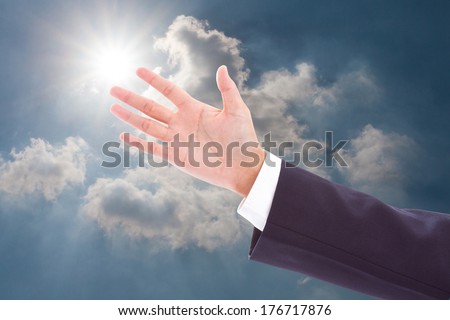 businessman showing something on the open palm in sky