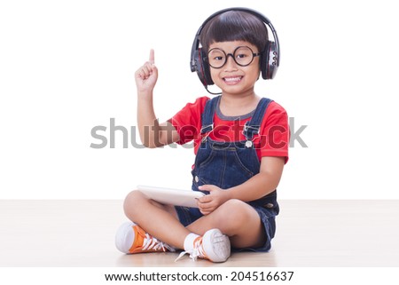 Happy boy with headphones connected to a tablet to listen to music