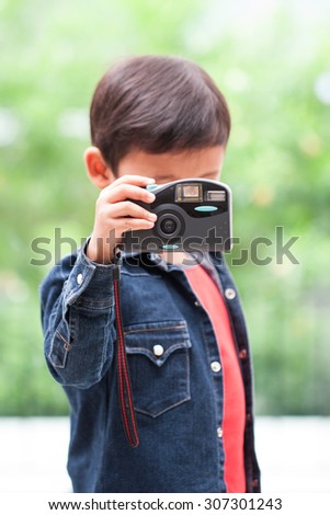 Cute boy using compact camera.