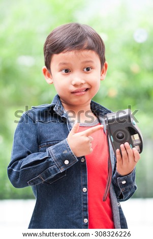 Happy asian boy with compact camera.