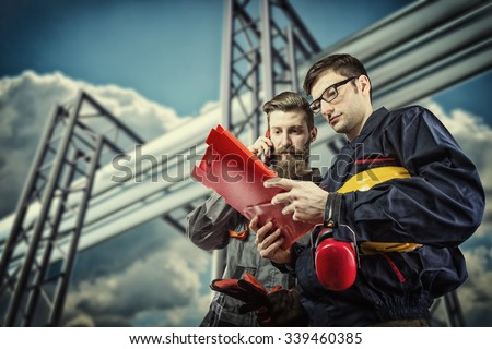 workers with protective helmet in front of industrial refinery oil pipes