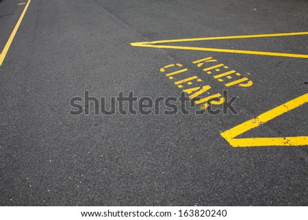ellow keep clear sign on a concrete road