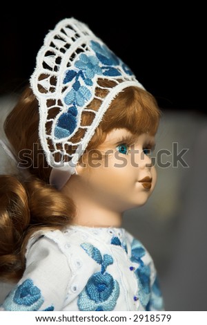 Doll in folk costume with blue traditional embroidery in Hungary.