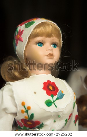 Doll in folk costume with red  traditional embroidery in Hungary.