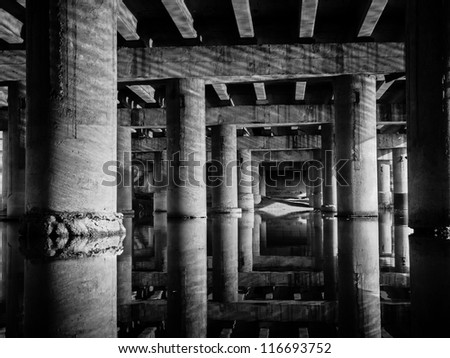 Perspective of supports under an old bridge over the river