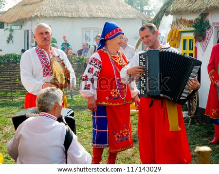 SUMY, UKRAINE - SEPTEMBER 22: Unidentified folk music band performs in traditional village background at annual agro exhibition SUMY-2012 on September 22, 2012 in Sumy, Ukraine