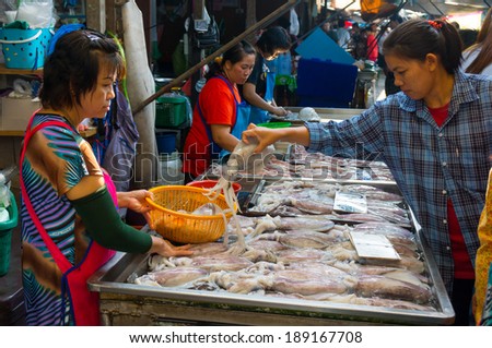 MAEKLONG, THAILAND - MARCH 24: Vendor sells fresh local fishery production on March 24, 2014 in famous Maeklong Railway Market also known as Talad Rom Hub or Umbrella Pulldown Market