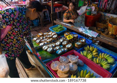 MAEKLONG, THAILAND - MARCH 24: Vendor sells fresh local agricultural production on March 24, 2014 in famous Maeklong Railway Market also known as Talad Rom Hub or Umbrella Pulldown Market