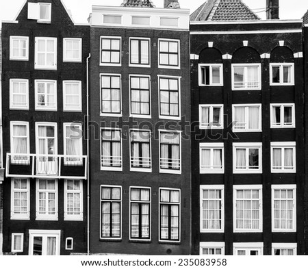 Facades of houses in old city in Amsterdam. Black and white