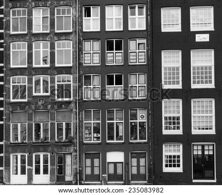 Facades of houses in old city in Amsterdam. Black and white