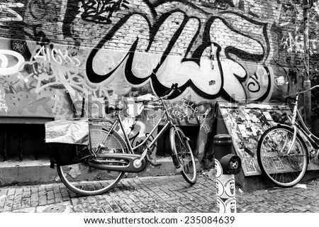 AMSTERDAM - AUGUST 31: Traditional dutch bicycle parked near brick wall painted with graffiti on August 31, 2014 in Amsterdam.