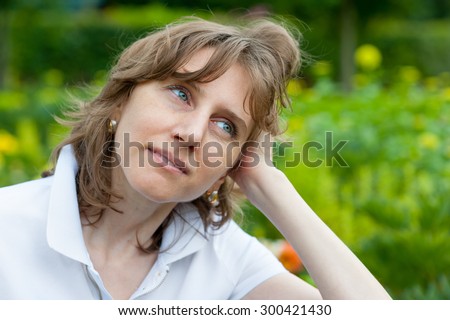 Middle age woman thinking in a park
