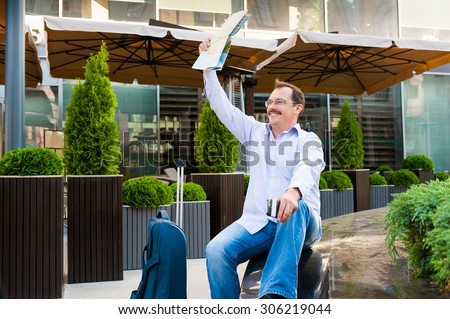 Businessman waving city map to someone. He is glad to meet