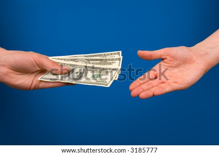 One hand gives money in other hand over blue background