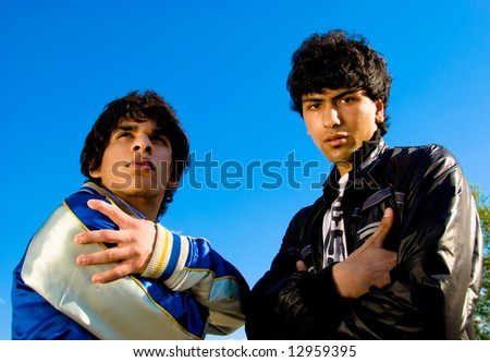 Two arabian guys portrait over blue sky background