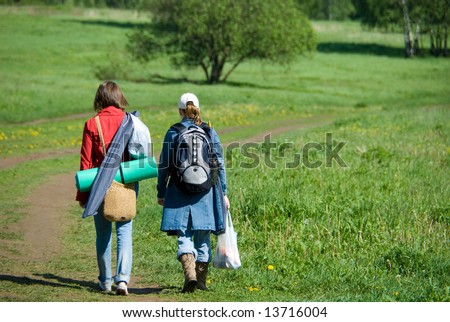 Two young women follow the path in a nature