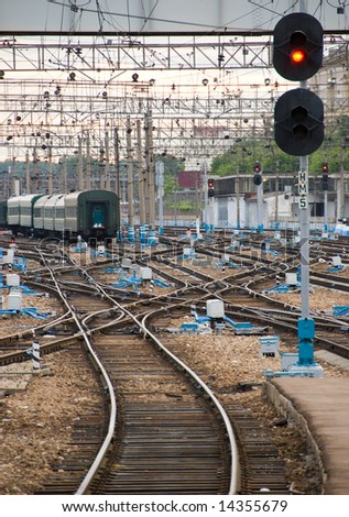 Railway junction. Perspective of crossing rails, traffic lights and train.