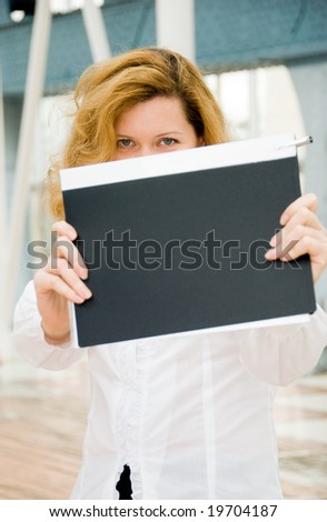Middle age business woman hides behind the folder