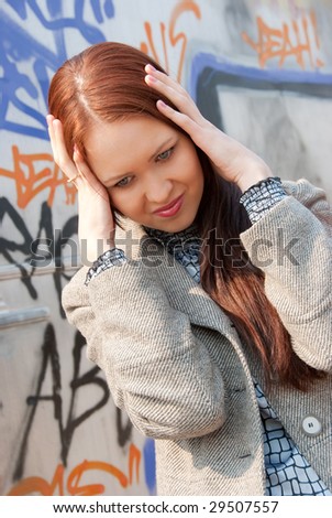 Young woman in despair. Graffiti on background