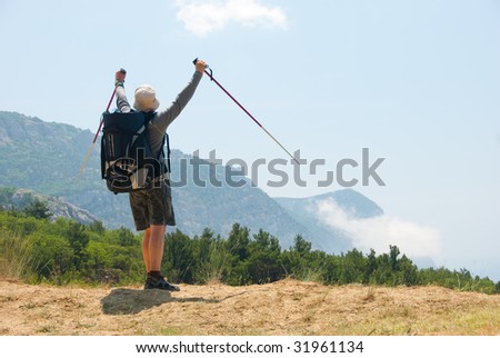 Happy hiker on a peak enjoys a landscape