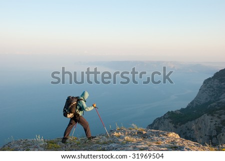 Hiker reaches peak with beautiful view to seashore landscape
