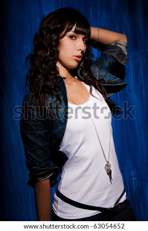 Beautiful young woman portrait in studio over grunge blue background