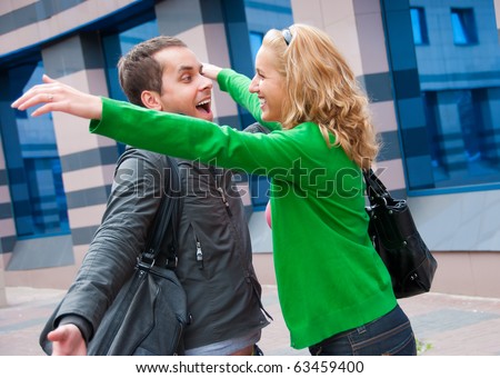 Two attractive young people met in the street and they are happy