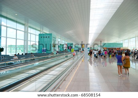 Interior of modern International Airport. No recognizable faces and advertising