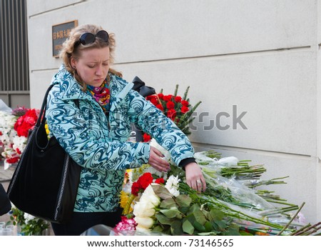 MOSCOW - MARCH 14: Unidentified people bring flowers to the Japanese embassy as a sign of sorrow and sympathy to the Japanese people affected by earthquake on March 14, 2011 in Moscow, Russia.