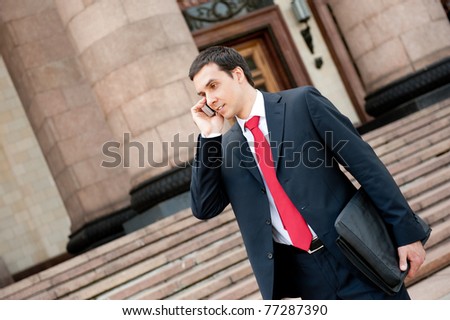 Businessman goes and calls on mobile in downtown