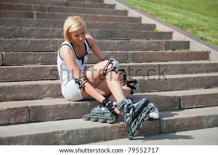 Young woman wears roller skates on the stairs