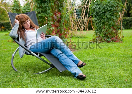 Young woman reading in tablet pc in the park